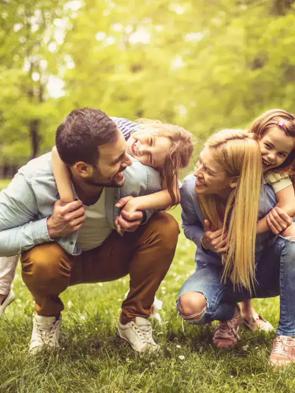 Famille heureuse avec deux enfants jouant dans un parc