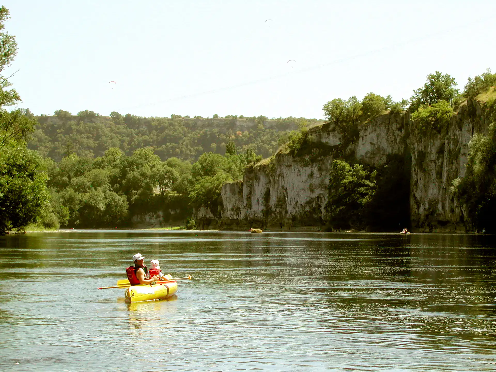 Canoë jaune avec deux personnes sur rivière falaises calcaires